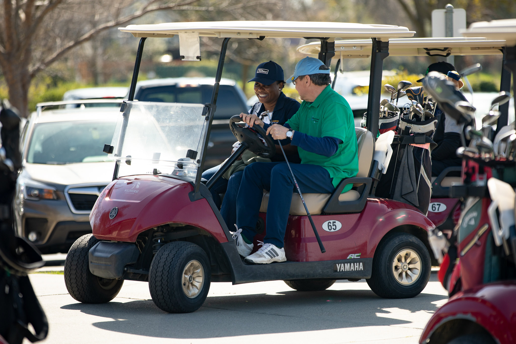 Two people in a golf cart.