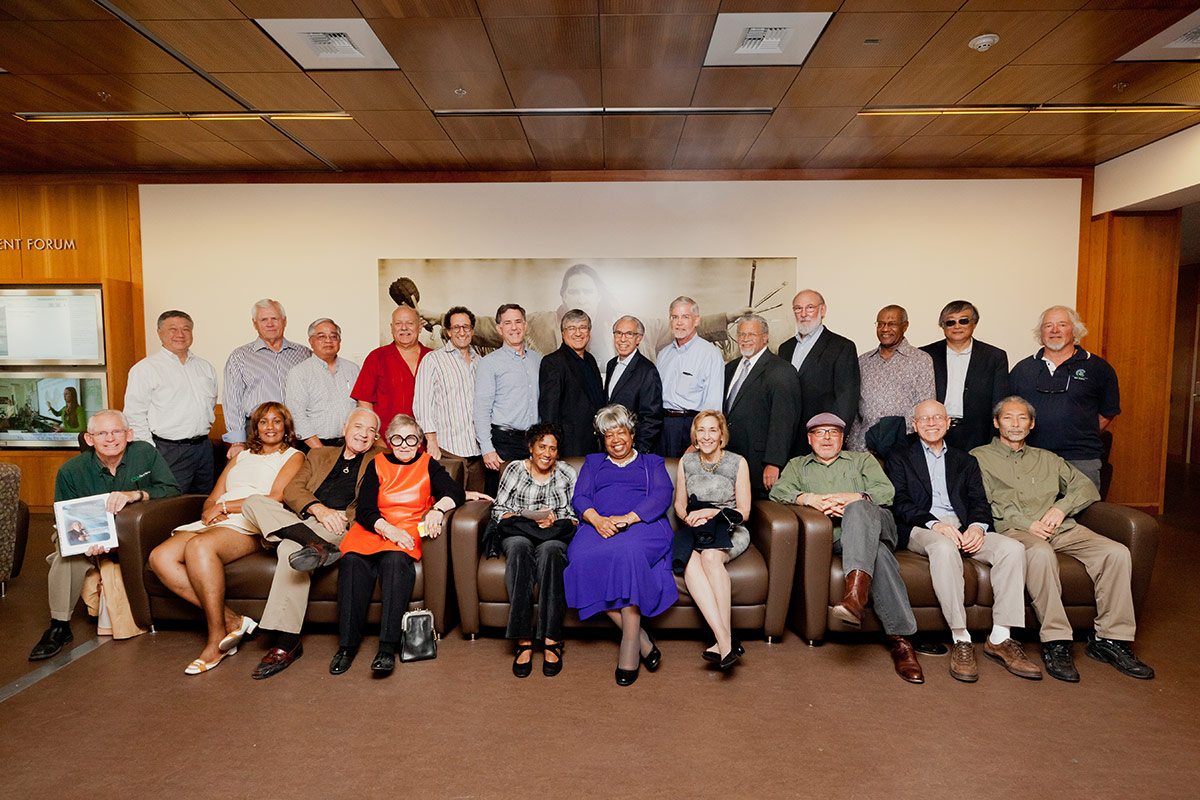Class of 1975 poses for a group photo in a lobby space at King Hall.