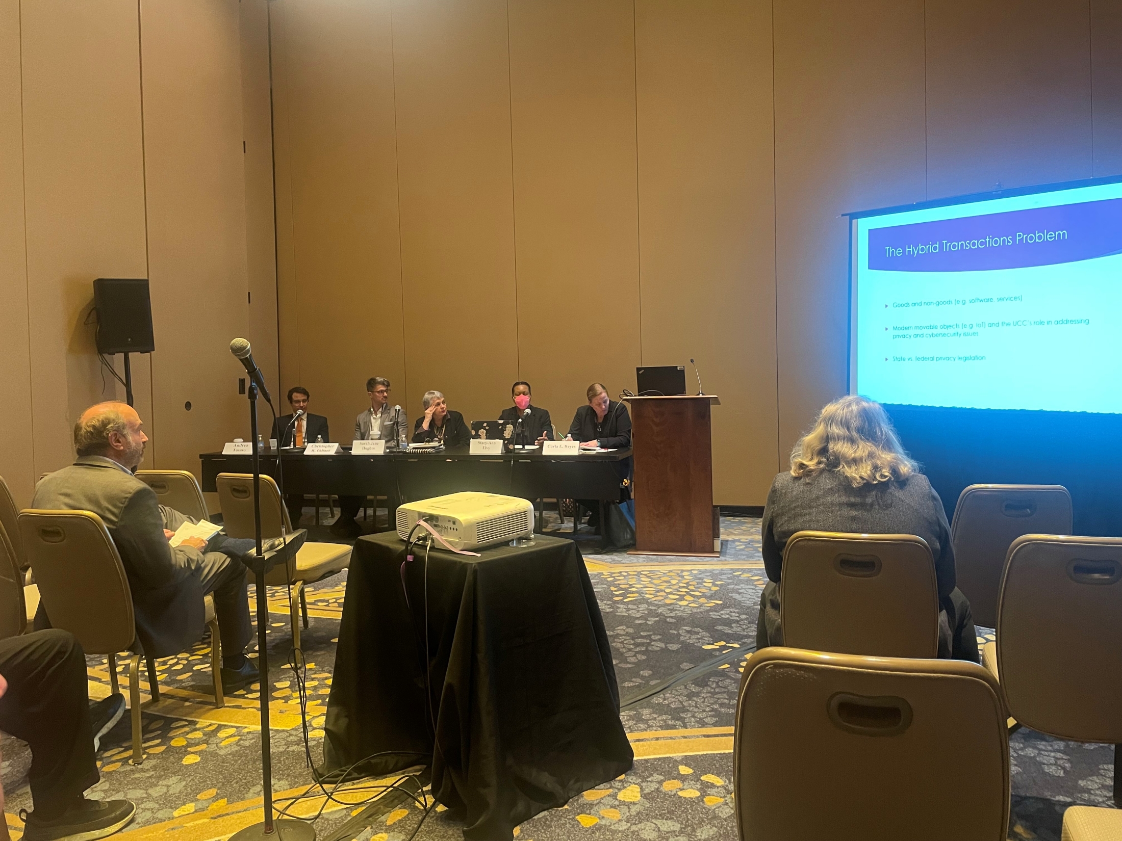 A panel of law experts presenting findings at a conference.