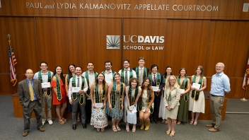 Group of UC Davis School of Law students and faculty in appellate courtroom, wearing stoles