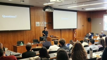 Speaker presenting to students in a university lecture hall