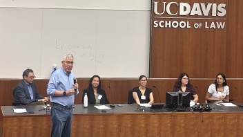 UC Davis School of Law panel, five people at front; one man standing and speaking