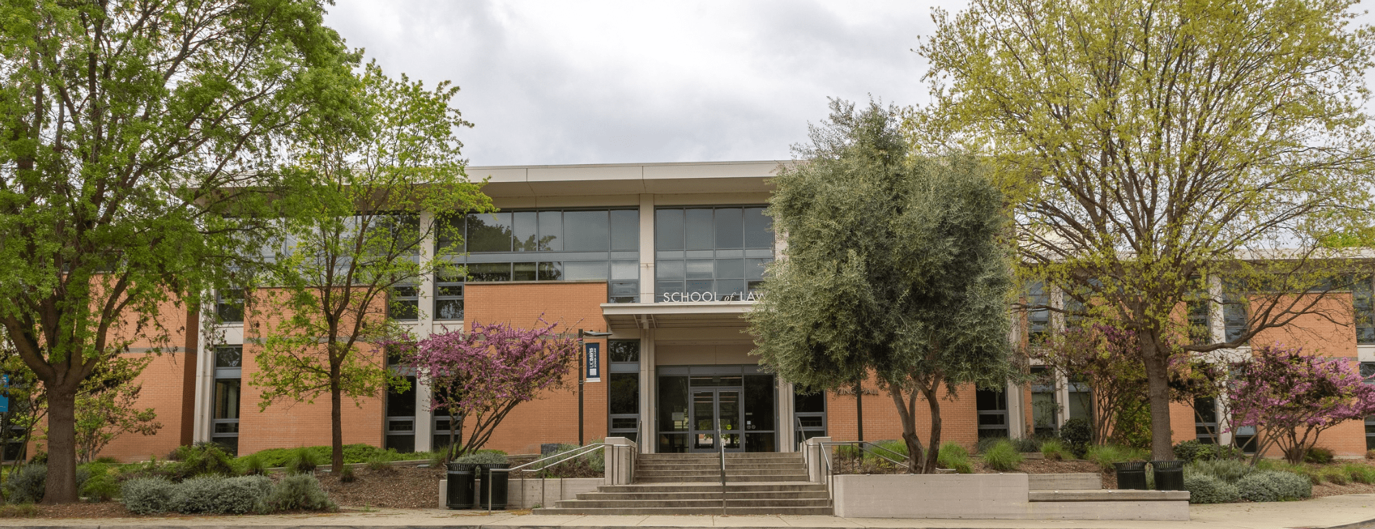 The UC Davis Law building on a spring day, with clouds in the sky.