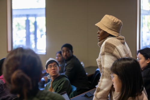 Students asking questions at an event in King Hall.