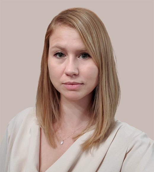Raelene Dugger, UC Davis Law's Assistant Director of Development, in white. She is softly smiling at the camera.