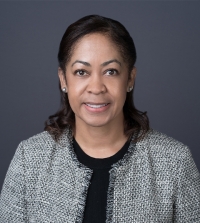 Stacy Boulware Eurie wearing a tweed jacket and smiling.