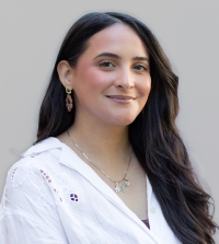 Angelita Mora, International's Admissions and Recruitment Specialist smiling at the camera in front of a white wall.